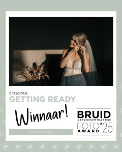 Bruidsfotograaf uit Twente, Foto Danielle Denekamp winnaar van de Bruidsfoto Award. De bruid staat in het zonlicht zich klaar te maken voor de grote dag.