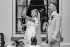 Bruidspaar opent champagne na de ceremonie op Landgoed Singraven Denekamp tijdens spontane trouwreportage.