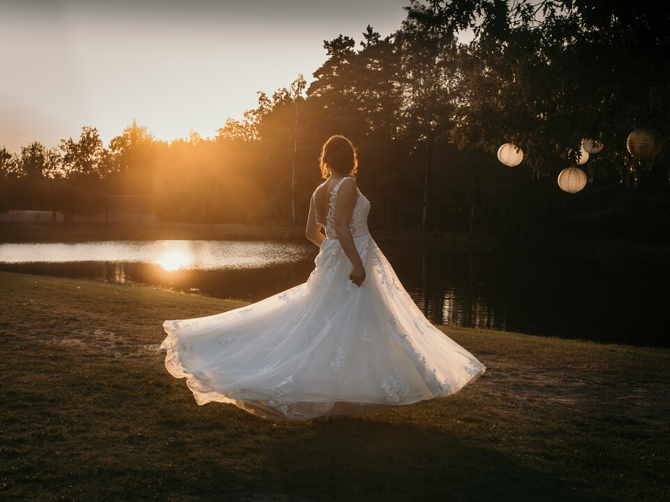 Een bruid danst bij zonsondergang bij de vijver van restaurant Fox.